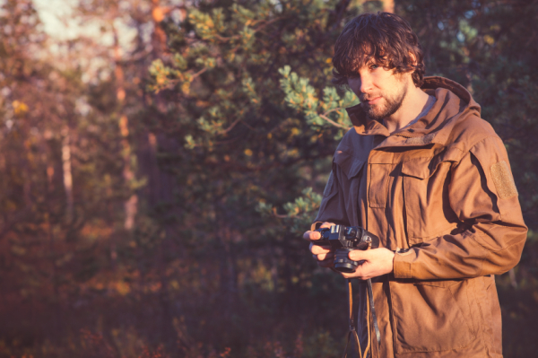 Young Man with retro photo camera outdoor Travel Lifestyle forest nature on background