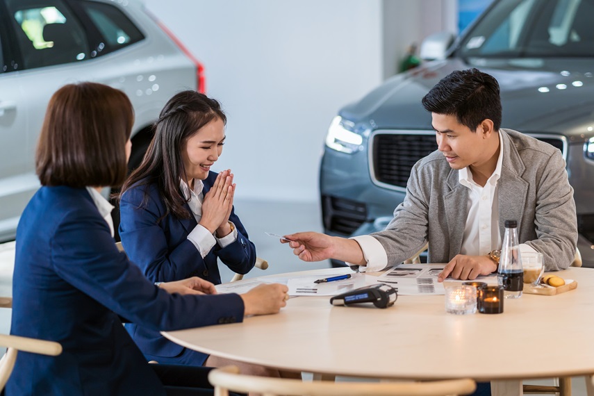 asian-customer-giving-credit-card-sales-representative-purchase-new-car